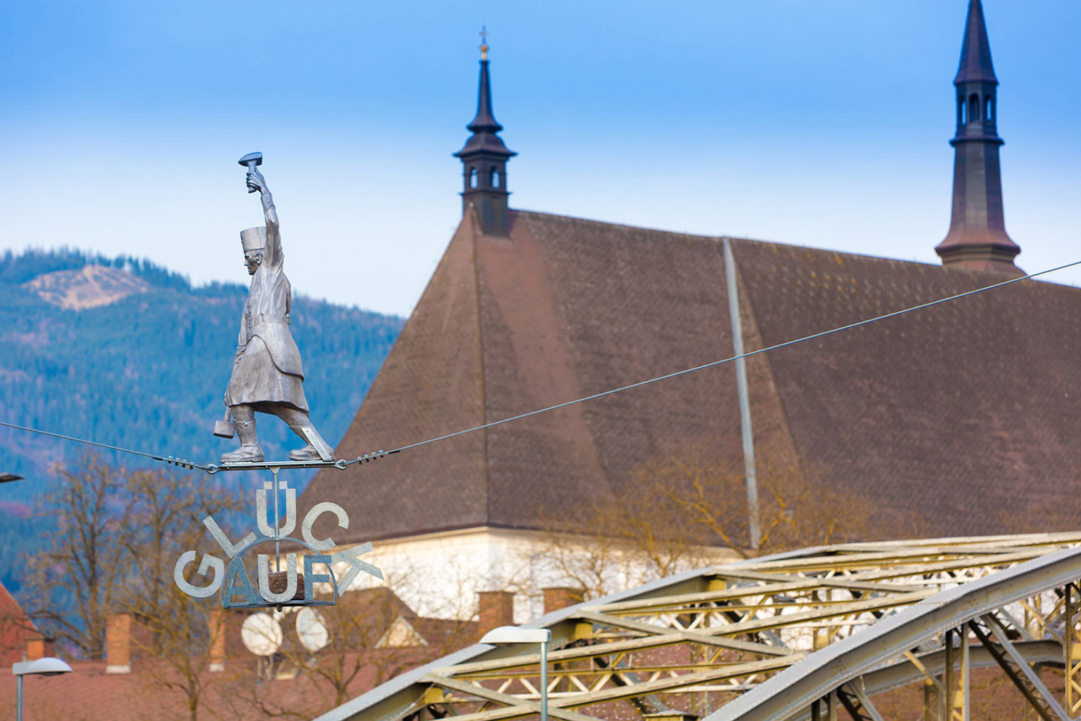 Figurine of a miner walking on a tightrope