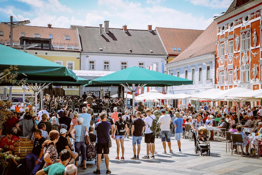 Zuhörer:innen am Hauptplatz Leoben mit Blick auf Bühne eines Platzkonzerts 2022