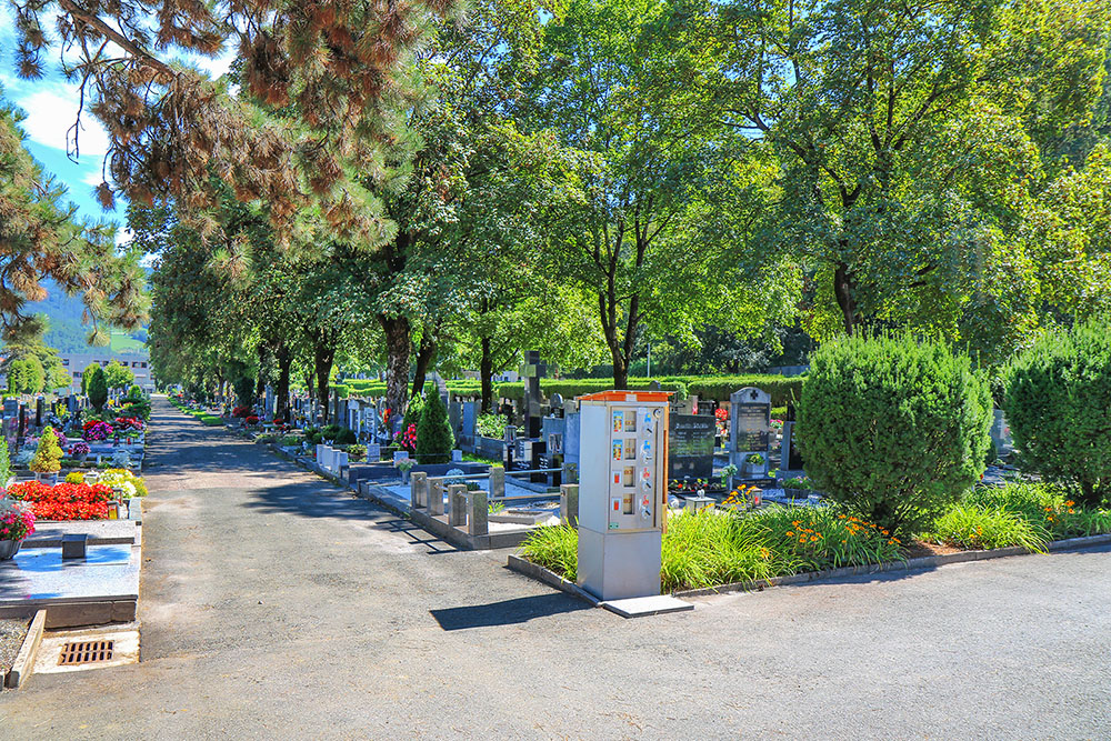 Kerzenautomat und Grabstätten im Sommer am Friedhof Donawitz