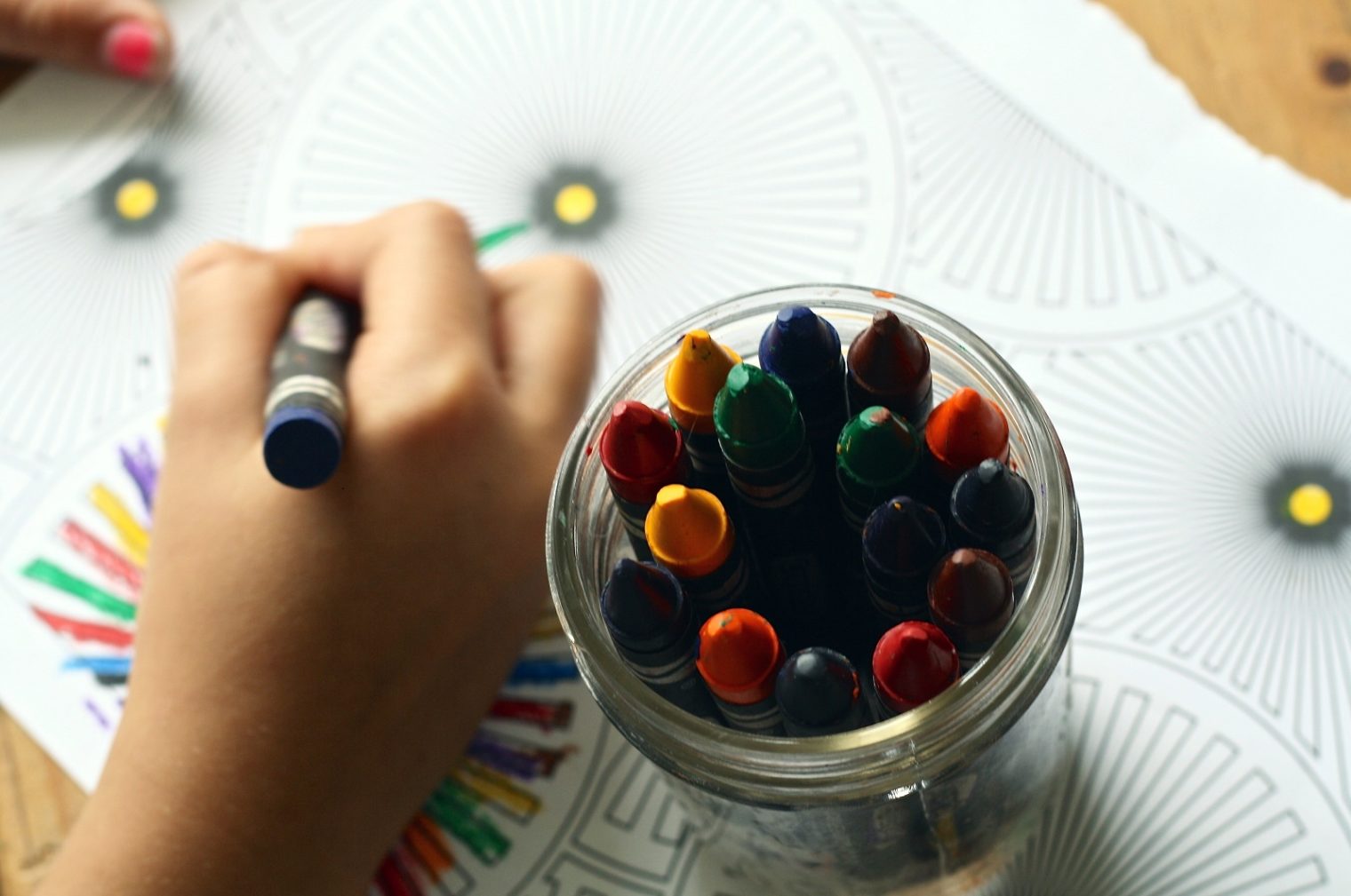Kinderhand zeichnet mit Ölkreide