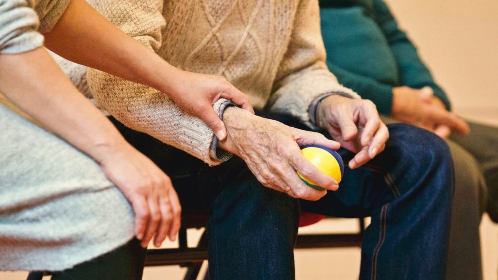 Frau hält Hand einer älteren Dame