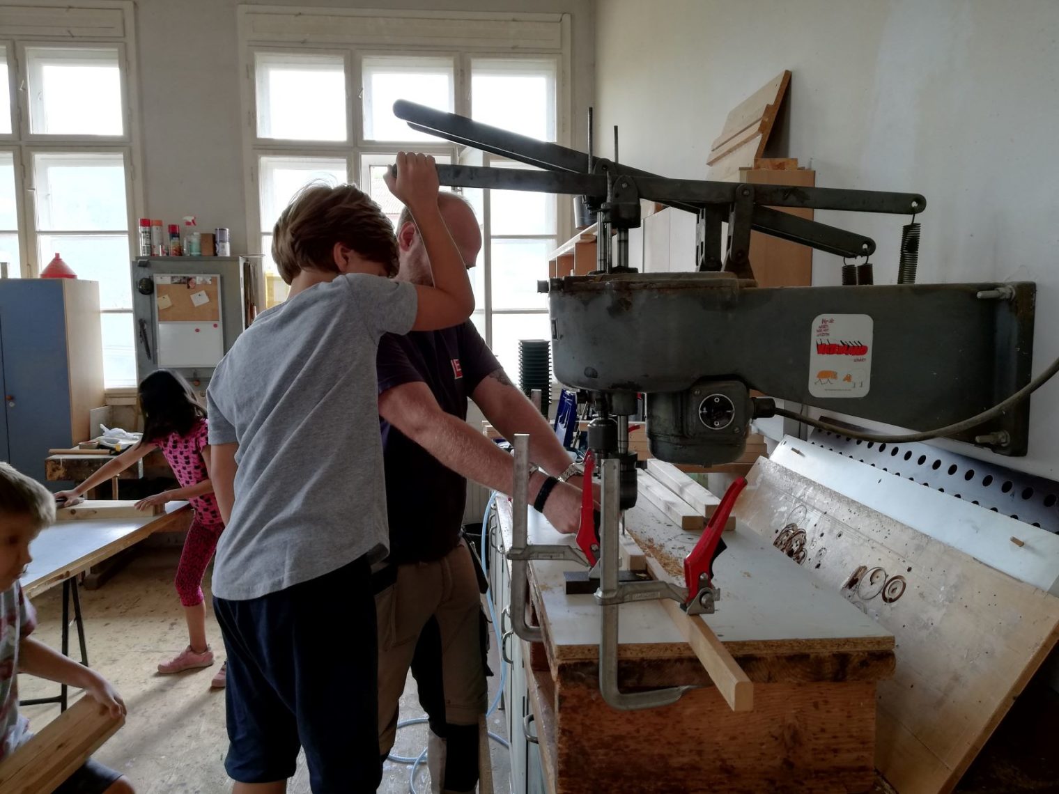 Kind mit Betreuer arbeiten an Fräßmaschine im Rahmen des Ferienprogramms Leoben