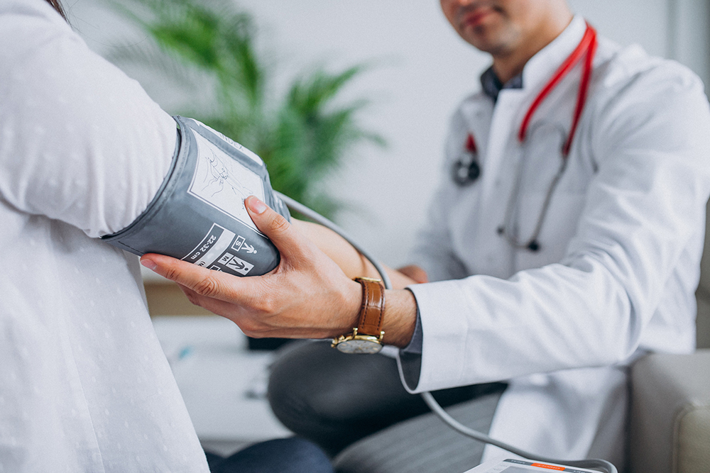 Arzt beim Blutdruck messen