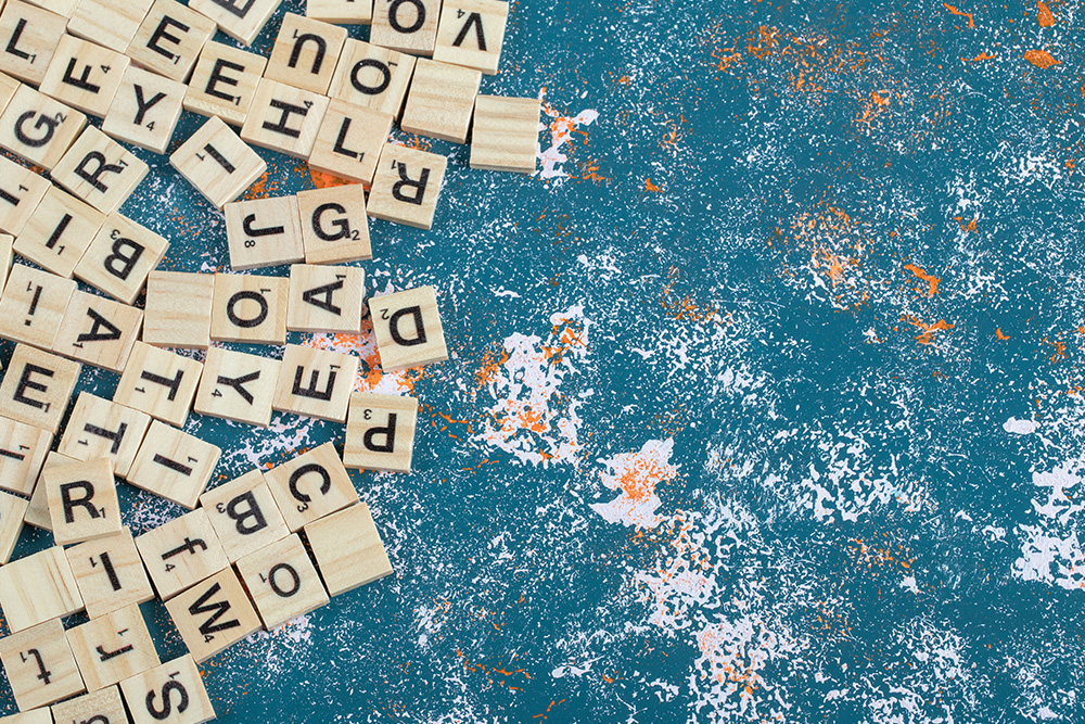Scrabble Buchstabenplättchen liegen verstreut auf Tisch