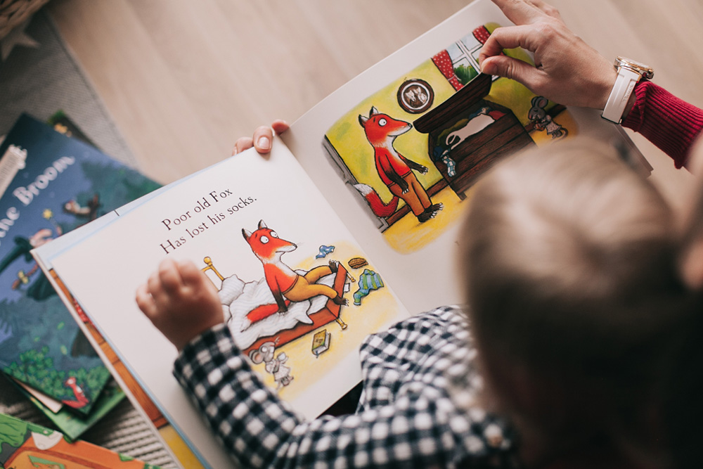 Symbolbild Kleinkind wird ein Buch vorgelesen