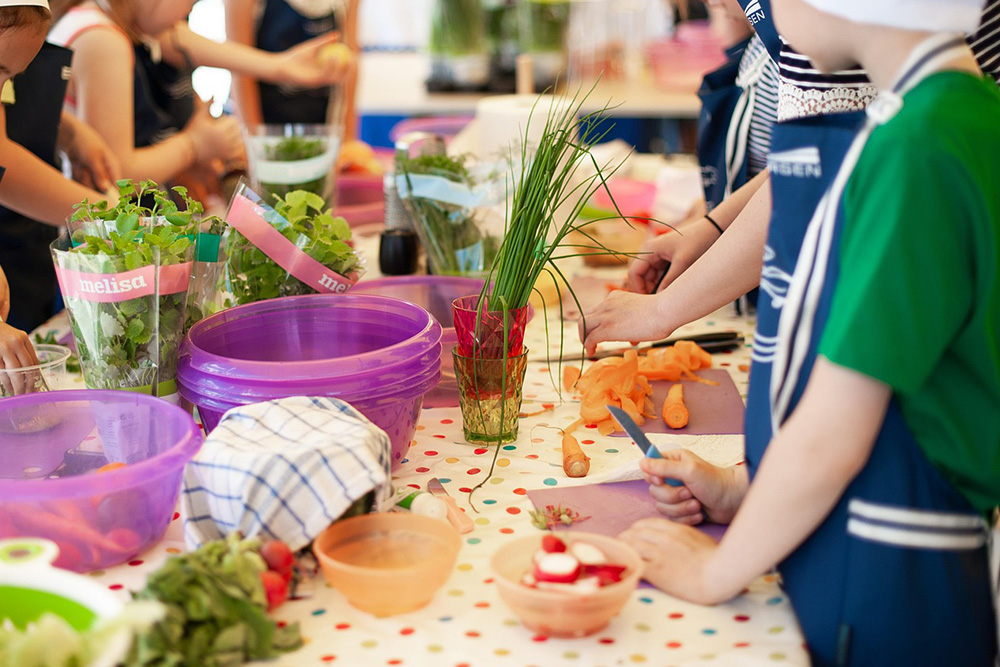Kinder schnippeln Gemüse am Tisch