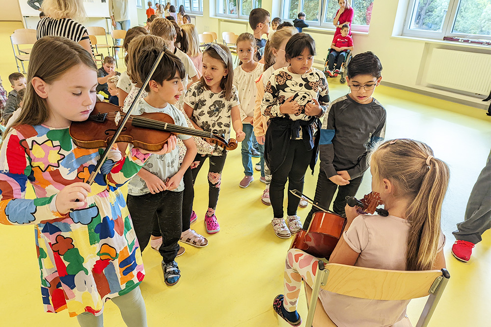 Eine Gruppe von Volksschulkindern übt mit Geigen