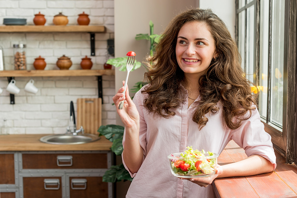 Frau mit Salatschüssel und Gabel in den Händen