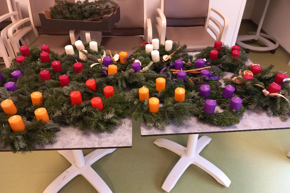 Bunte Adventkränze auf zwei Tischen