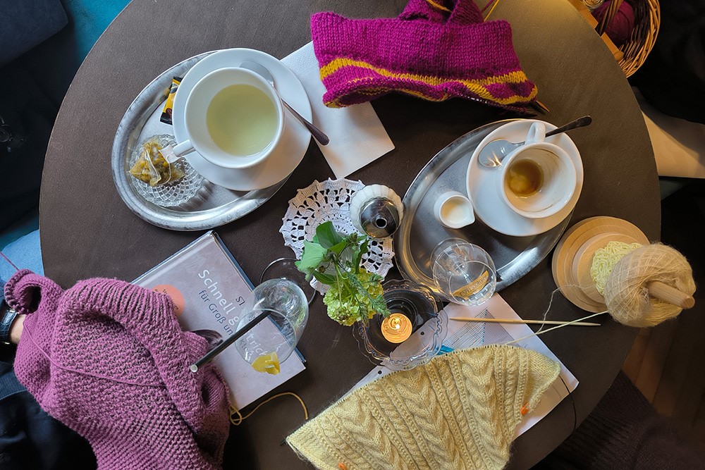 Kaffeetisch mit Strick-und Häkelwerkstücken und Kaffeetasse