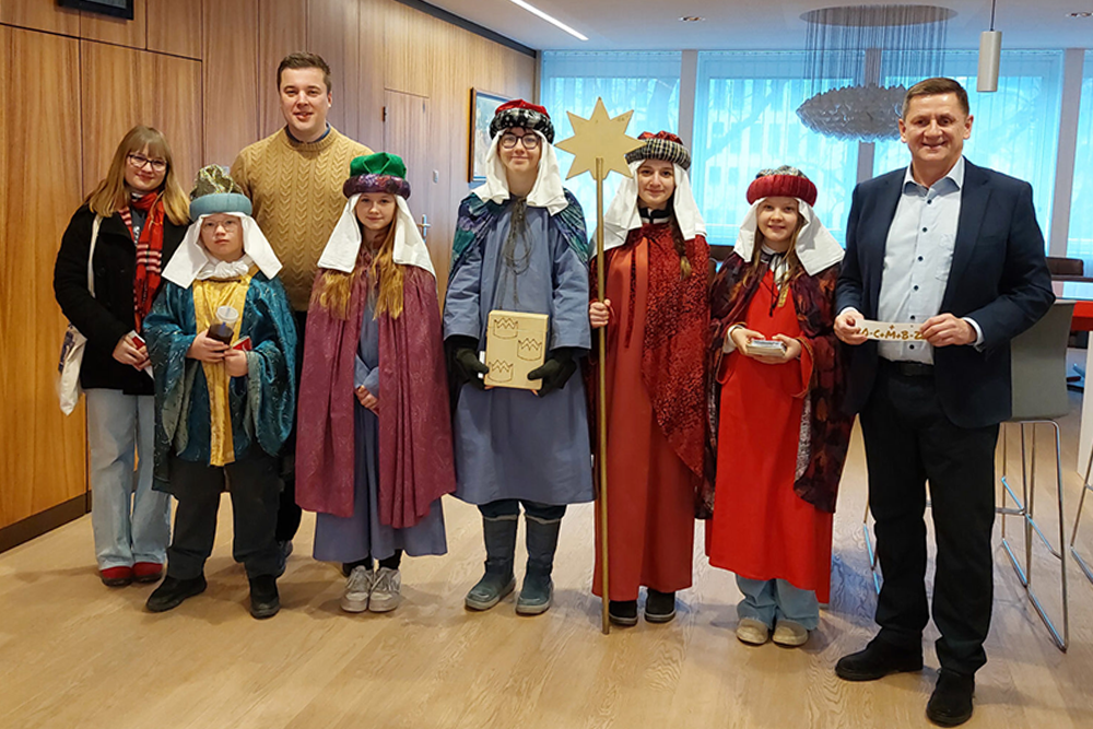 Gruppenbild der Sternsinger:innen mit Bürgermeister und Kulturreferenten