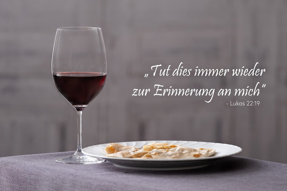 Glas Rotwein und Speiseteller am Tisch