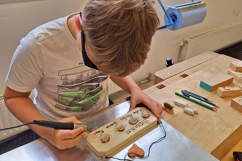 Bub beim Basteln eines Türschildes