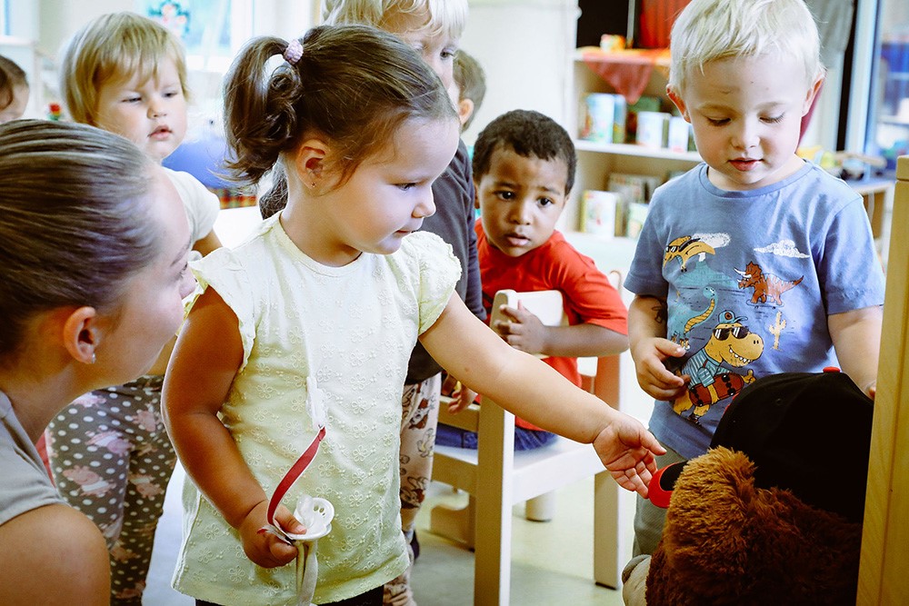 Kinder im Kindergarten spielen mit Stofftier