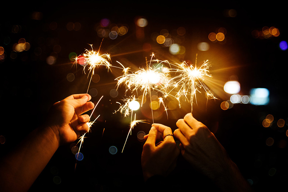 Sternspritzer Wunderkerzen in drei Händen gehalten